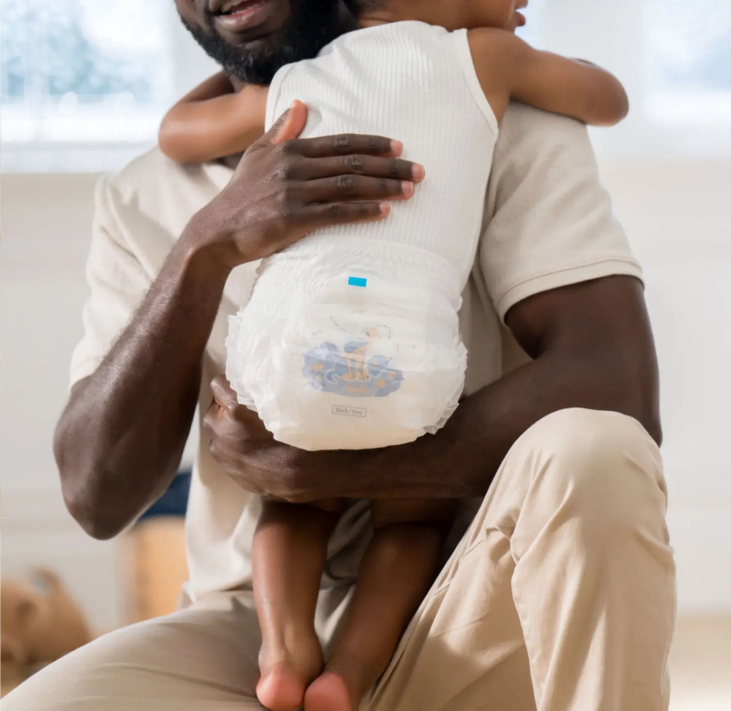Parent holding baby wearing Millie Moon diapers